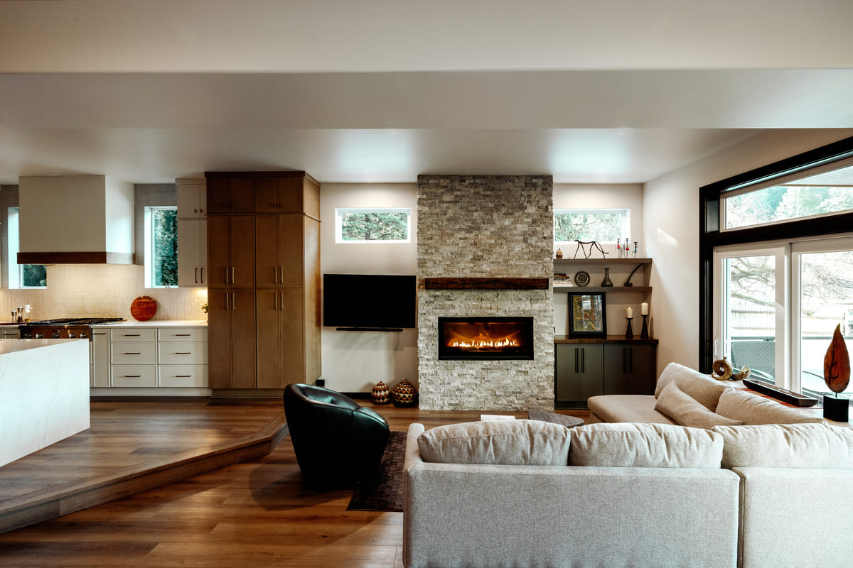 Cozy modern living room featuring a rock fireplace, comfortable seating, and stylish contemporary finishes.